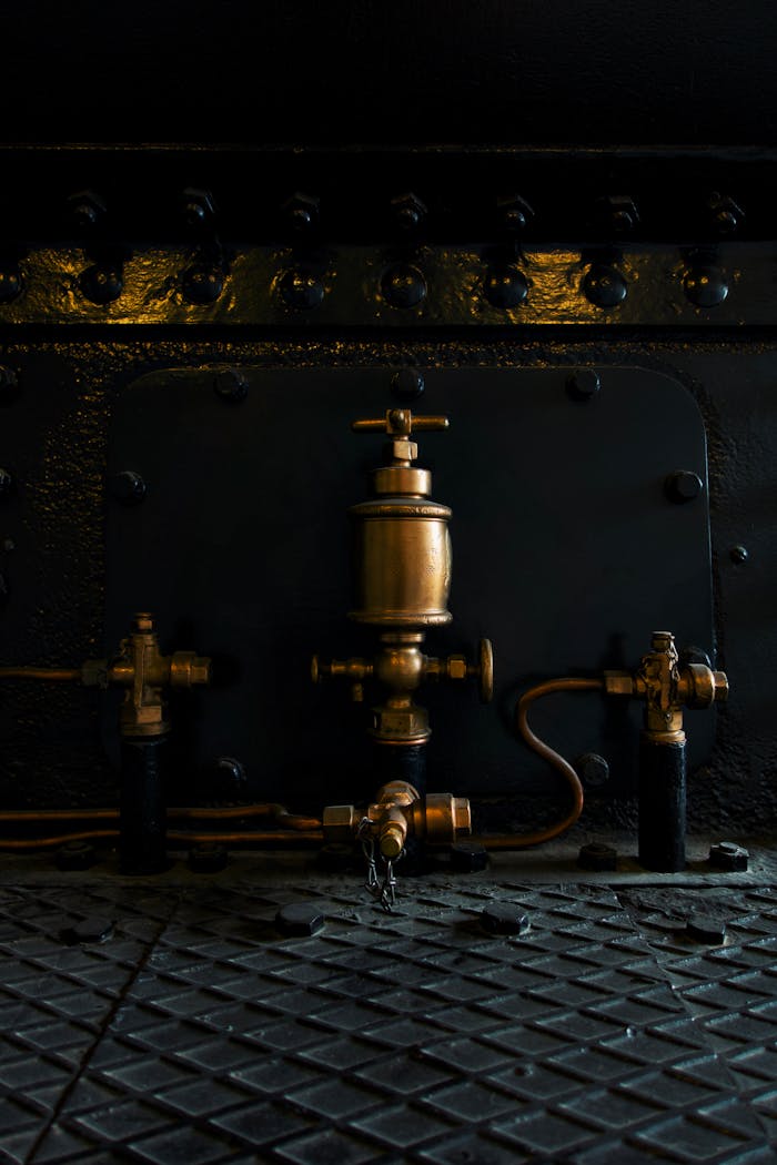 services-05 Close-up of a brass valve on a steam engine, showing intricate details.